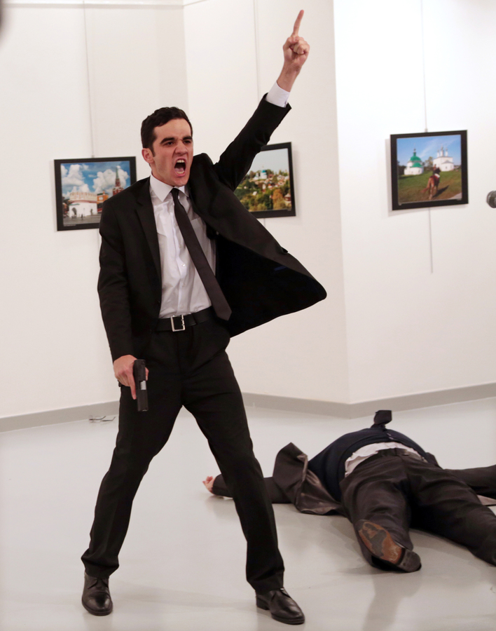 Mevlut Mert Altintas shouts after shooting Andrei Karlov, right, the Russian ambassador to Turkey, at an art gallery in Ankara, Turkey, Monday, Dec. 19, 2016.  (AP Photo/Burhan Ozbilici)